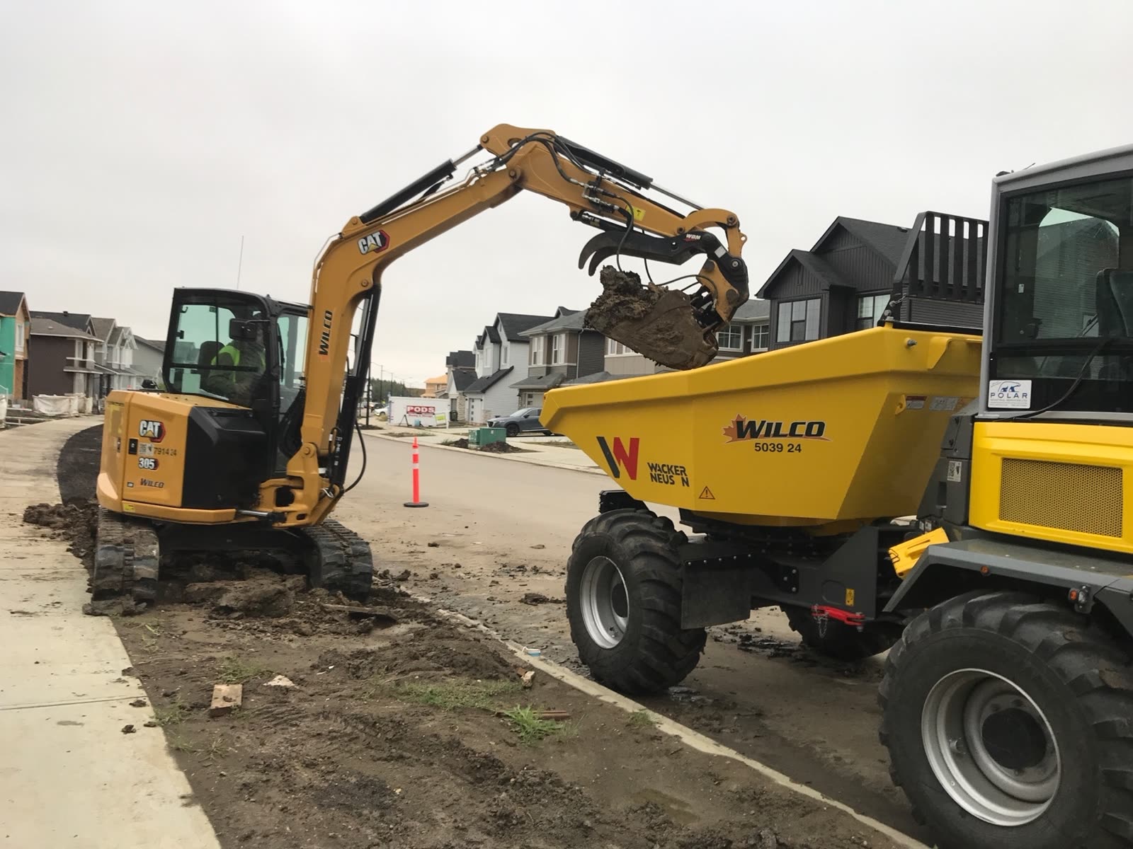 A Wilco-branded dumper and excavator working in a new Wilco neighbourhood